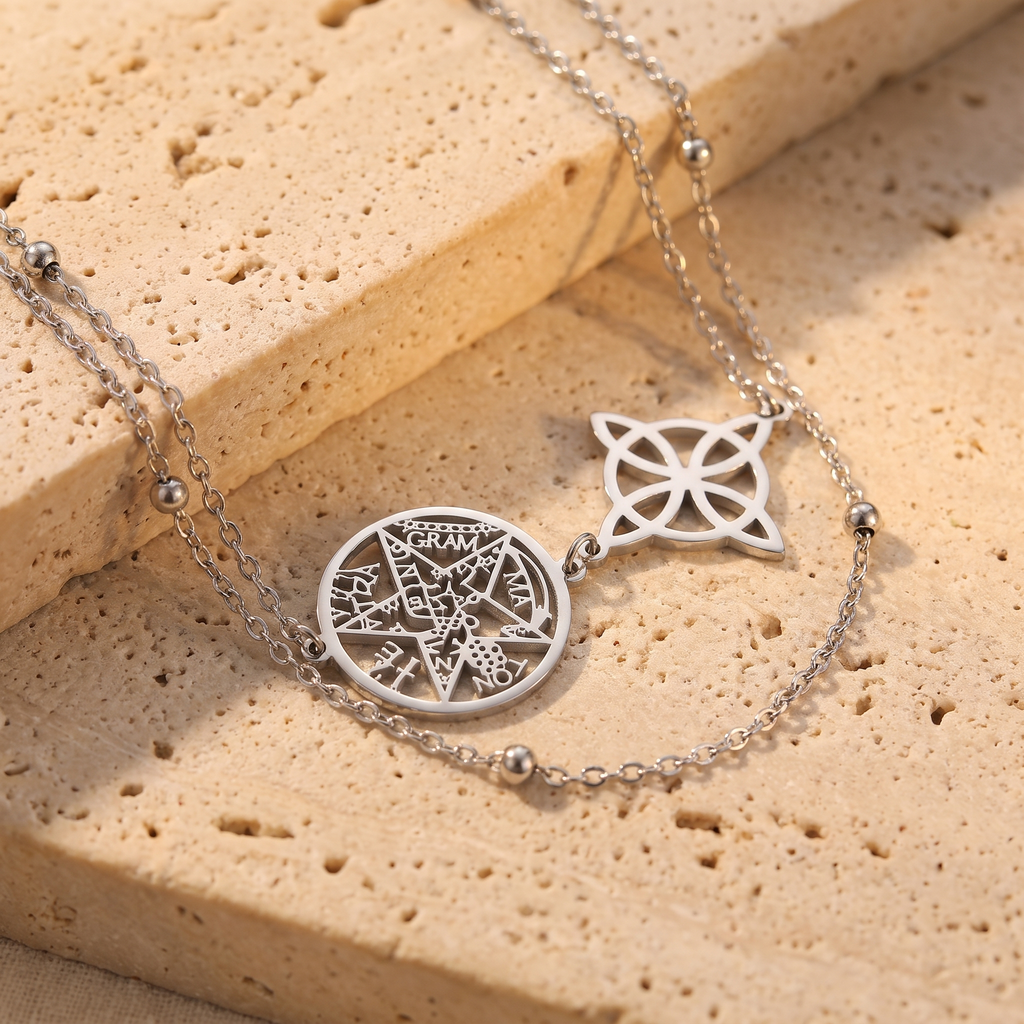 Gros plan sur les médaillons nœud de sorcière et pentacle argentés