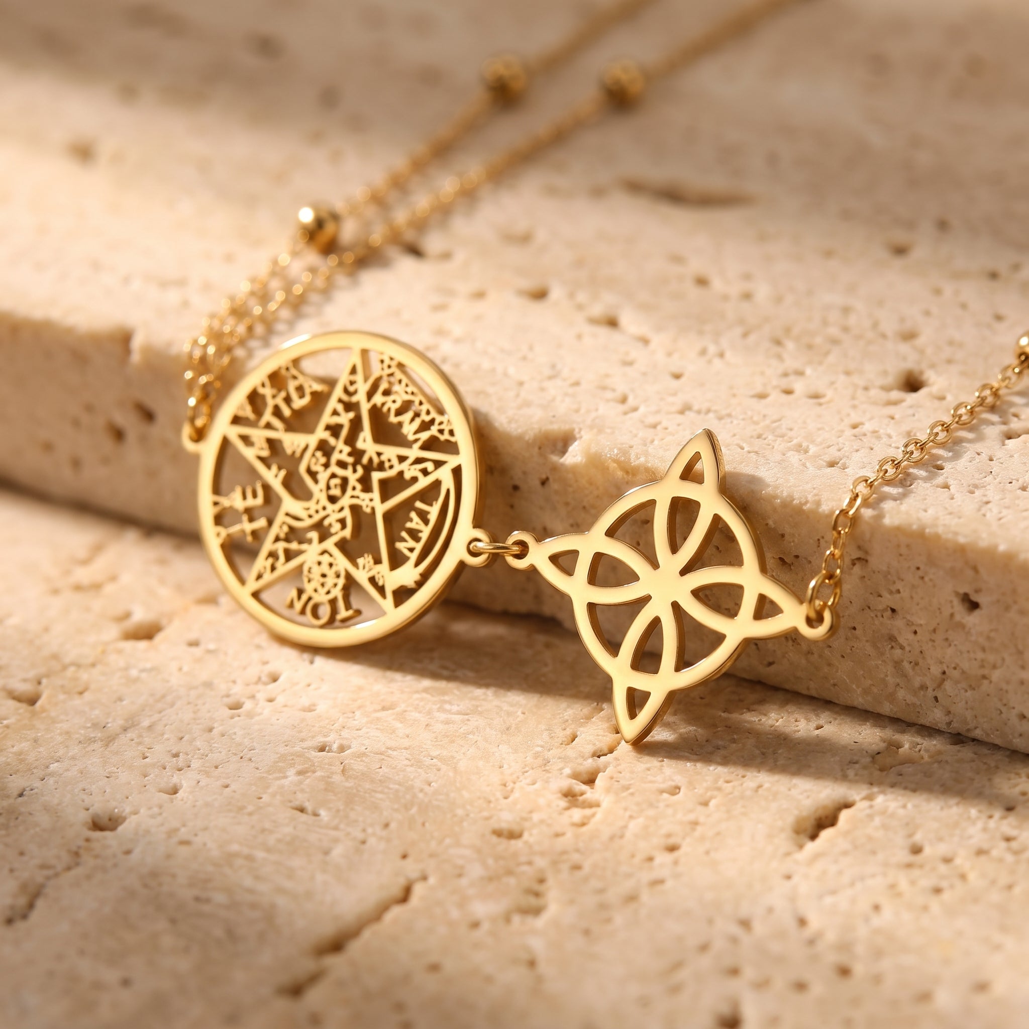 Gros plan sur les médaillons nœud de sorcière et pentacle dorés