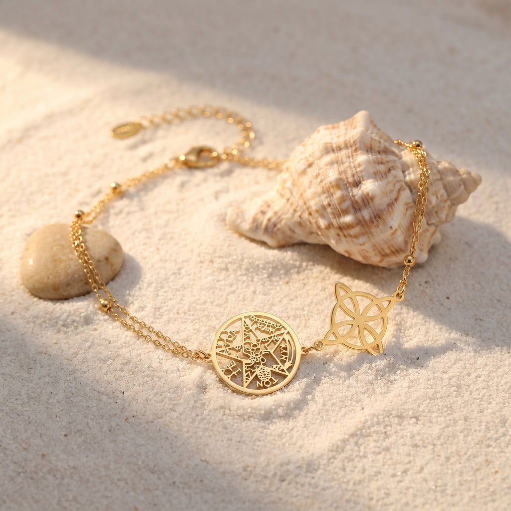 Chaîne de cheville nœud de sorcière et pentacle dorée sur le sable avec coquillage