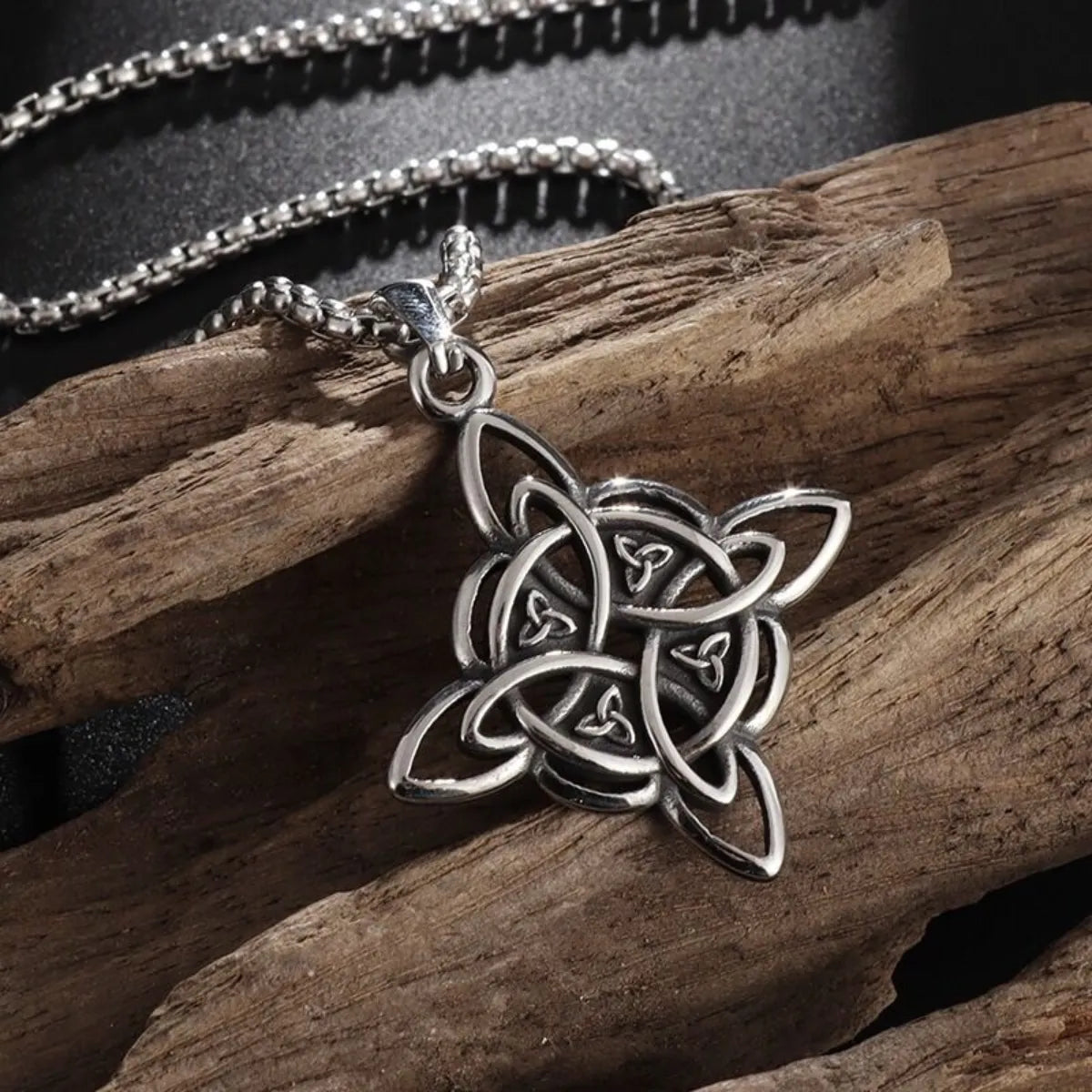 Collier Nœud des Sorcières en argent vieilli posé sur bois rustique