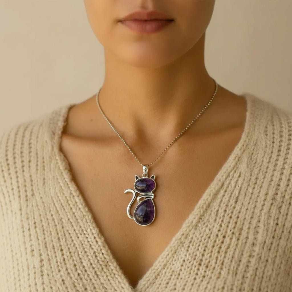 Pendentif chat en améthyste porté autour du cou avec pull beige