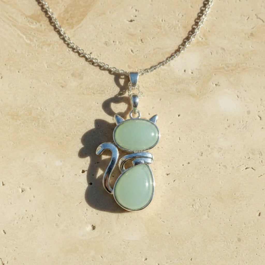 Pendentif chat en pierre naturelle aventurine verte sur fond travertin beige